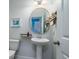 Tastefully decorated powder room featuring a pedestal sink, round mirror, and stylish fixtures at 2017 Geranium Ln, Johns Island, SC 29455