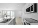 Well-lit kitchen features stainless appliances, quartz countertops, white cabinets, and view of exterior doors to backyard at 212 Terrace View Dr, Summerville, SC 29486
