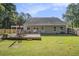 Expansive backyard with a wooden deck, mature trees, and a partially covered patio with outdoor seating at 214 Deer Ridge Court Ct, Huger, SC 29450