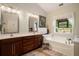 Bathroom with double vanity, soaking tub, and window offering natural light at 214 Deer Ridge Court Ct, Huger, SC 29450