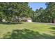 Expansive front yard featuring lush lawn, mature trees, and a charming house with a long driveway at 214 Deer Ridge Court Ct, Huger, SC 29450
