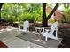 Relaxing backyard patio area with two white Adirondack chairs and a small side table at 2206 Hunter Creek Dr, Charleston, SC 29414