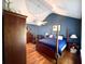 Stylish bedroom with wood floors, a four-poster bed, dark blue walls, and a large wardrobe at 2206 Hunter Creek Dr, Charleston, SC 29414