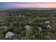 Scenic aerial view of a lush community with homes nestled among trees at sunset at 2340 Marsh Hen Dr, Seabrook Island, SC 29455