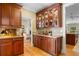 Classic butler's pantry with cherry cabinets, granite countertop, and glass-front display cabinets at 2340 Marsh Hen Dr, Seabrook Island, SC 29455