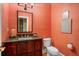 Vibrant powder room featuring textured coral walls, granite countertop, and modern fixtures at 2340 Marsh Hen Dr, Seabrook Island, SC 29455