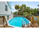 Backyard with an inviting in-ground pool, framed by a wooden deck and lush palm trees at 2407 Cameron Blvd, Isle of Palms, SC 29451