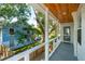 Inviting porch with wood ceiling overlooks a beautifully landscaped yard and neighboring home at 2407 Cameron Blvd, Isle of Palms, SC 29451