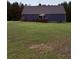 Back of house with wooden deck, large lawn, with blue siding, and tree-lined backdrop at 2460 Bama Rd, Cottageville, SC 29435