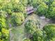 Discover a house nestled among the trees in this aerial view, highlighting the property's privacy and greenery at 24678 Augusta Hwy, Cottageville, SC 29435