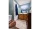 Bathroom with toilet, wood vanity and large mirror, plus earth toned walls, flooring, and seat cover at 24678 Augusta Hwy, Cottageville, SC 29435