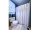 Cozy bathroom featuring a toilet, shower curtain, and window for natural light at 24678 Augusta Hwy, Cottageville, SC 29435