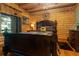 Bedroom featuring log walls, hardwood floors, a ceiling fan, and a comfortable bed with decorative pillows at 24678 Augusta Hwy, Cottageville, SC 29435