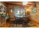Inviting dining area featuring log walls, hardwood floors, a round table, and rustic decor at 24678 Augusta Hwy, Cottageville, SC 29435