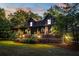 Charming log home with covered porch, manicured lawn, and warm exterior lighting at 24678 Augusta Hwy, Cottageville, SC 29435