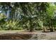 Picturesque log cabin surrounded by mature trees and lush landscaping at 24678 Augusta Hwy, Cottageville, SC 29435