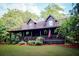 Quaint log home with cozy covered porch and decorative foliage for country living at 24678 Augusta Hwy, Cottageville, SC 29435