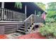 Charming log cabin exterior with a wooden porch, stairs, and an American flag at 24678 Augusta Hwy, Cottageville, SC 29435