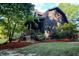 A log home with lush landscaping and a covered porch at 24678 Augusta Hwy, Cottageville, SC 29435
