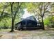 Scenic view of a log cabin nestled among mature trees with a covered porch at 24678 Augusta Hwy, Cottageville, SC 29435