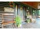 Charming log cabin porch with rocking chair, swing, and plants for a cozy outdoor space at 24678 Augusta Hwy, Cottageville, SC 29435