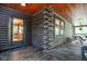 Spacious porch of log cabin providing seamless transition to the outdoors, wood ceiling and homey welcome mat at 24678 Augusta Hwy, Cottageville, SC 29435