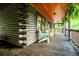 Log cabin porch featuring cozy seating areas, beautiful views, and rustic charm at 24678 Augusta Hwy, Cottageville, SC 29435