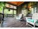 Relaxing log cabin porch with comfortable seating and a serene view of the outdoors at 24678 Augusta Hwy, Cottageville, SC 29435