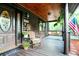 Quaint log cabin porch with rocking chair, swing, and plants for a cozy outdoor space at 24678 Augusta Hwy, Cottageville, SC 29435