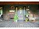 Charming log cabin front porch with seating, decorative wreath, and welcoming decor at 24678 Augusta Hwy, Cottageville, SC 29435