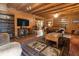 Cozy log cabin living room featuring wood floors, beamed ceilings, and built-in shelves at 24678 Augusta Hwy, Cottageville, SC 29435