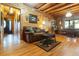 Inviting living room featuring log walls, hardwood floors, a comfortable couch, and rustic decor at 24678 Augusta Hwy, Cottageville, SC 29435