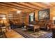 Relax in this cozy living room with log walls, wood floors, and comfortable seating at 24678 Augusta Hwy, Cottageville, SC 29435