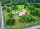 Expansive aerial view of property with a pool, lush greenery, charming home, and red metal roof at 274 Harvest Rd, Moncks Corner, SC 29461