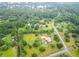 Aerial view showing a home with metal roof amid verdant trees, roads, and a glimpse of a nearby lake at 274 Harvest Rd, Moncks Corner, SC 29461