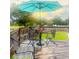 Wooden back deck with a metal table and chairs, with an umbrella and a green lawn in the background at 274 Harvest Rd, Moncks Corner, SC 29461