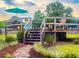 Wooden back deck with stairs, seating, landscaping, and a teal umbrella overhead at 274 Harvest Rd, Moncks Corner, SC 29461