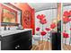 Bathroom with black vanity, white sink and toilet, and floral decor at 274 Harvest Rd, Moncks Corner, SC 29461
