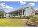 Beautiful exterior of a single-story home featuring a welcoming covered front porch and a red metal roof at 274 Harvest Rd, Moncks Corner, SC 29461