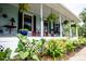 Inviting covered porch with comfortable seating is surrounded by lush landscaping at 274 Harvest Rd, Moncks Corner, SC 29461
