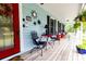Covered porch with bright decor, black shutters, and lots of seating creates a warm welcome at 274 Harvest Rd, Moncks Corner, SC 29461