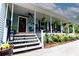 Charming front porch with seating, decor, and landscaping welcomes you to this lovely light blue home at 274 Harvest Rd, Moncks Corner, SC 29461