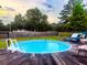 Above ground pool with ladder and wooden deck, surrounded by green grass and a wooden fence at 274 Harvest Rd, Moncks Corner, SC 29461