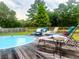 Above ground pool with lounge chairs and pillows, with a wooden deck and fence at 274 Harvest Rd, Moncks Corner, SC 29461