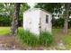 Tan backyard shed surrounded by greenery, featuring a window and decorative elements at 274 Harvest Rd, Moncks Corner, SC 29461