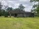 Rear view of a brick home showing a covered parking area and verdant lawn at 379 Chestnut Rd, Walterboro, SC 29488