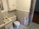 Bathroom featuring patterned wallpaper, a white toilet and sink, plus a shower with curtains at 379 Chestnut Rd, Walterboro, SC 29488
