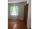 Bedroom featuring hardwood floors, a window with lace curtains, and a closet with folding doors at 379 Chestnut Rd, Walterboro, SC 29488