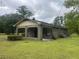 Side view of a brick house with a lattice trimmed covered porch, and a lush green lawn at 379 Chestnut Rd, Walterboro, SC 29488