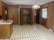View of a kitchen with wood walls, black and white checkerboard flooring, and access to the laundry area at 379 Chestnut Rd, Walterboro, SC 29488